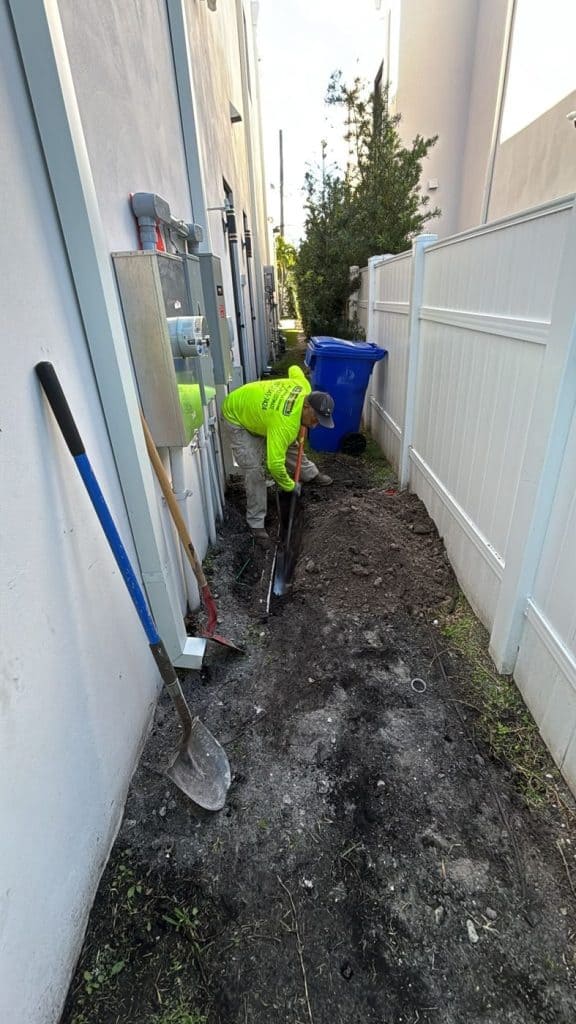 Boring Bros crew trenching a tight side yard for new utility lines — serving Sea Ranch Lakes, FL