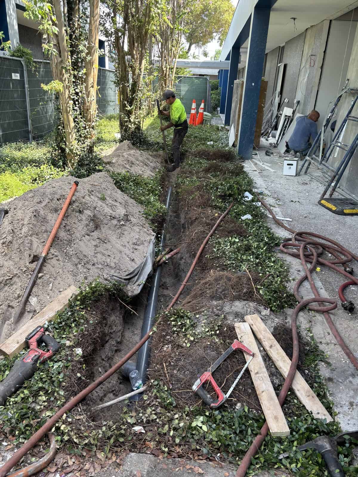 Workers installing underground piping at Boring Bros construction site.