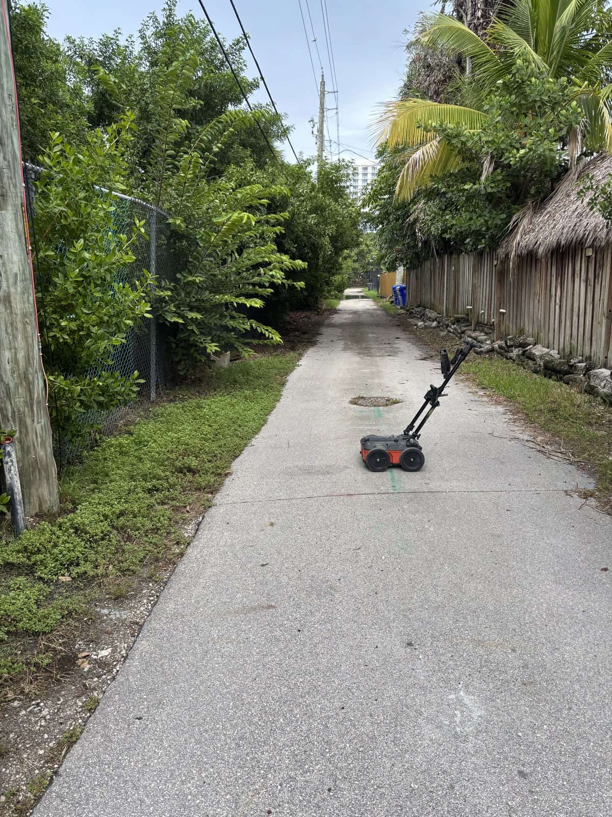 Ground penetrating radar cart in a narrow concrete service alley with green locate marks in Hollywood